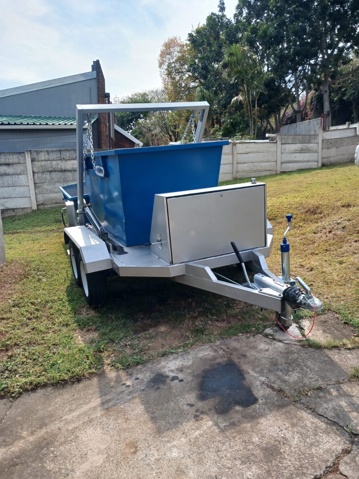 Blue mini skip trailer positioned in a yard for collection service