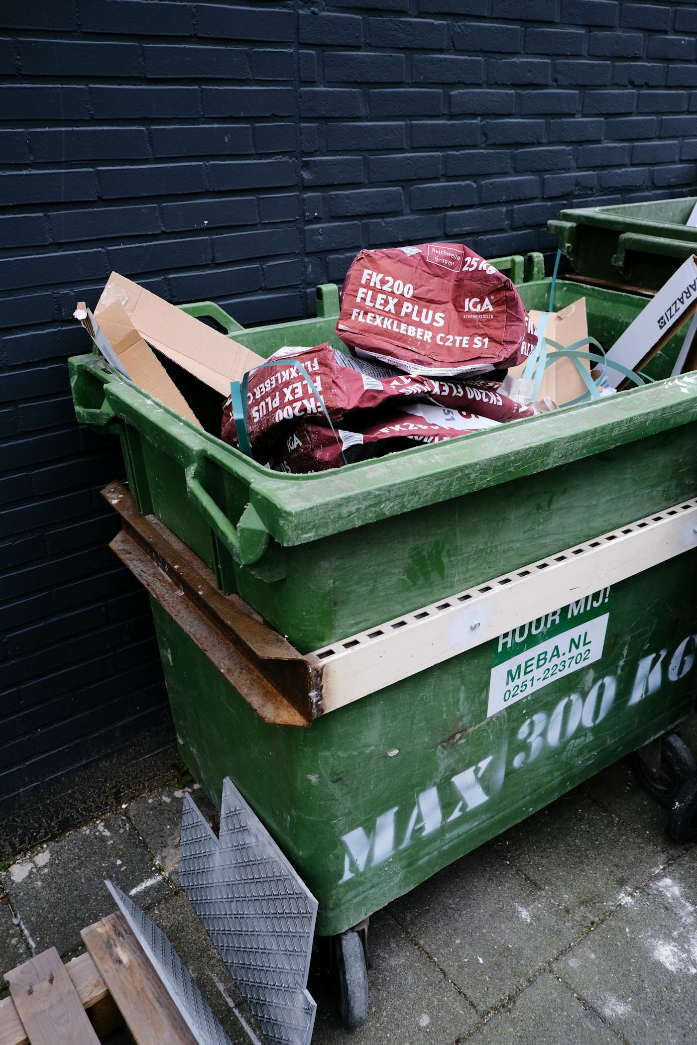 Green waste container filled with cardboard and renovation material