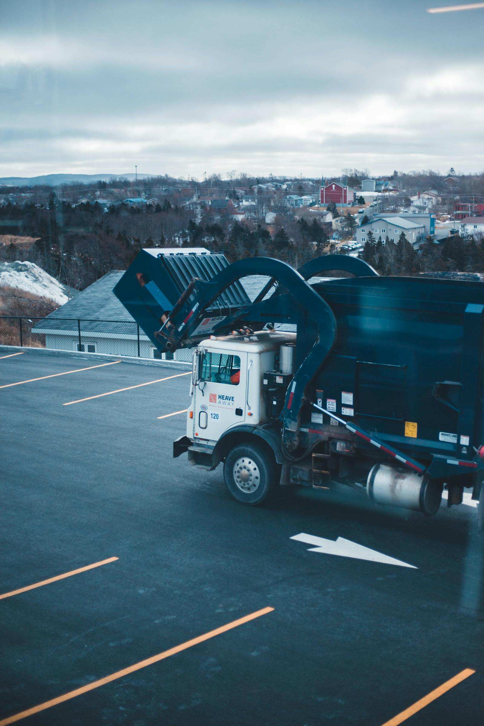 Waste management truck operating in a service yard